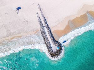 An aerial view of City Beach, Western Australia, showing a pier leading out into the ocean