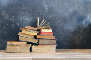 Stack of multicolored books with open one, education and reading, back to school concept, copy space