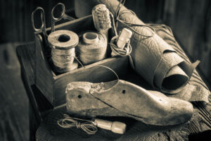 Small shoemaker workplace with tools, shoes and laces